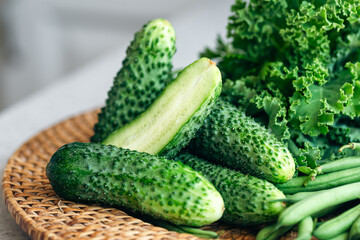 Plate with cucumbers, kale, parsley and green beans, close-up.