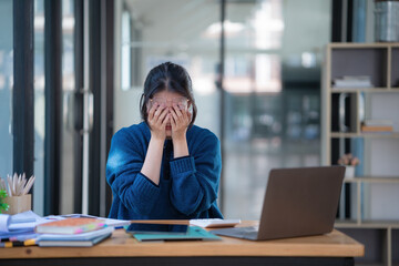 Young Asian businesswomen with office syndrome have a problem with feeling headaches and stress...