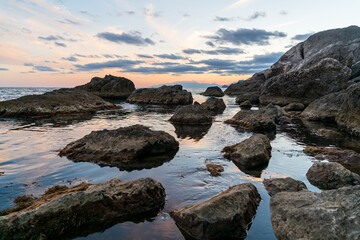 Fototapeta na wymiar Sudak, Crimea. Bright contrasting sky after sunset. Rocks in the black sea