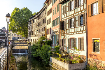 Fototapeta na wymiar Strasbourg, France - June 19, 2023: Traditional half-timbered houses on the picturesque canals of La Petite France in the medieval town of Strasbourg, UNESCO World Heritage Site, Alsace, France
