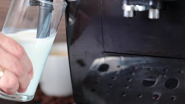 Preparation of latte - the coffee maker froths milk in a glass of milk. Coffee.