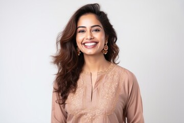 Medium shot portrait of an Indian woman in her 20s wearing salwar kameez against a white background