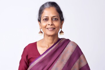 Lifestyle portrait of an Indian woman in her 50s wearing traditional sari against a white background