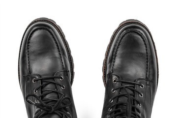 Pair of black leather boots, dress boots for men, men ankle high boots. Black brogue boots on a white background. Men fashion in leather boots. Man's legs in black jeans and brown leather boots.