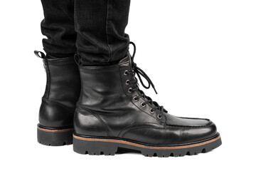 Pair of black leather boots, dress boots for men, men ankle high boots. Black brogue boots on a white background. Men fashion in leather boots. Man's legs in black jeans and brown leather boots.