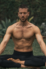 Obraz premium young man doing yoga meditation in a park