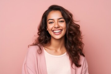Fototapeta premium Portrait of a beautiful young woman laughing and looking at camera isolated over pink background