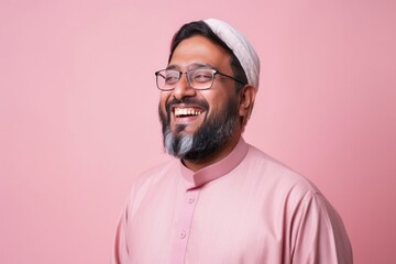 Obraz premium Portrait of a happy indian man in pink shirt on pink background
