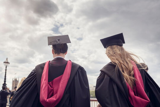 University graduates at graduation ceremony in the city, boy and girl standing together