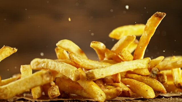 Super Slow Motion of Flying French Fries. Filmed on High Speed Cinema Camera, 1000fps, Placed on High Speed Cine Bot. Camera in Motion, Following Objects. Speed Ramp Effect.