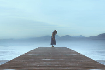 lonely woman standing on a pier by the sea gets carried away by emotions in a blue surreal atmosphere - obrazy, fototapety, plakaty