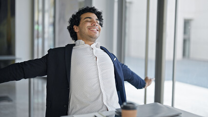 Fototapeta premium Young latin man business worker finishing to work relaxing at office