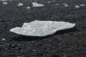 Black Stone Beach Scattered with Ice Chunks