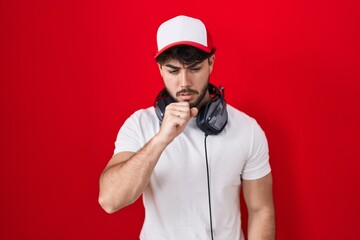 Hispanic man with beard wearing gamer hat and headphones feeling unwell and coughing as symptom for cold or bronchitis. health care concept.