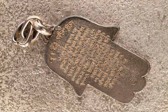 One metal keyring, Jewish "Hand of Miriam" on metal, close-up, top view.