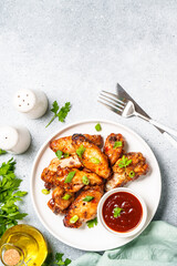 Grilled meat. Chicken wings in bbq sauce.. Top view on white stone table.