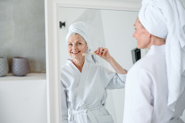 Reflection in mirror of woman with wide healthy smile