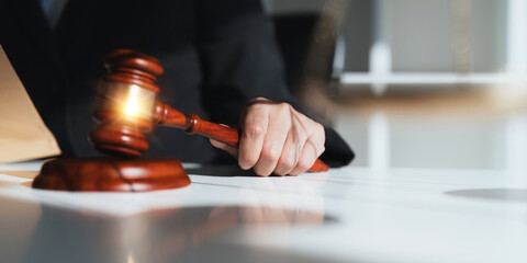 Photography of a judge hold judges gavel with justice lawyers at law firm in background. concepts of law