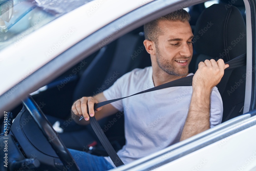 Sticker Young caucasian man smiling confident wearing car belt at street