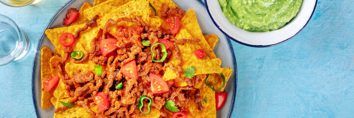Nachos panorama, Mexican food, tortilla chips with beef and fresh vegetables, with guacamole dip,...