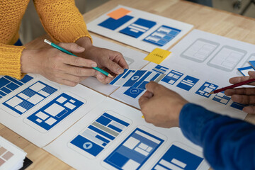 A team of web designers are working together to develop a mobile responsive website with UI/UX...