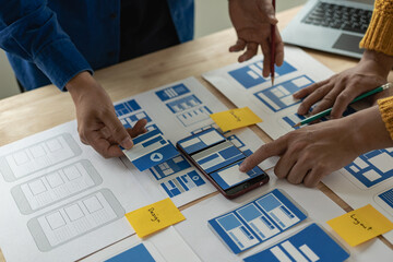 A team of web designers are working together to develop a mobile responsive website with UI/UX...