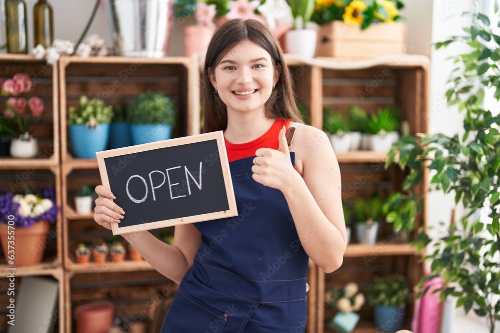 Canvas Prints Young caucasian woman working at florist holding open sign smiling happy and positive, thumb up doing excellent and approval sign