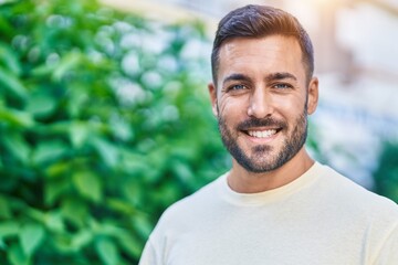 Young hispanic man smiling confident standing at park