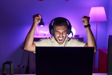 Young hispanic man streamer playing video game with winner expression at gaming room © Krakenimages.com