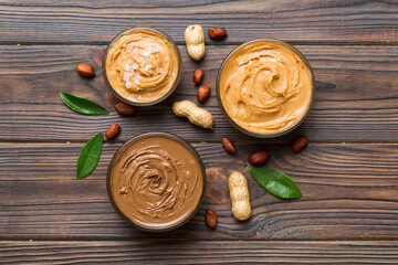 Glass jar with peanut butter on table background, top view space for text and close up