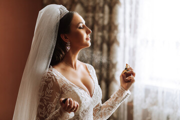 Female beauty. Cute woman at home. The bride sprays perfume on her body. A stylish woman wears a...