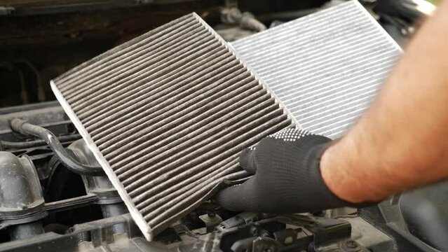 The old clogged air filter is replaced with a new one. Car repair and maintenance.