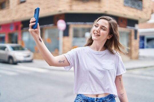 Young woman smiling confident making selfie by the smartphone at street