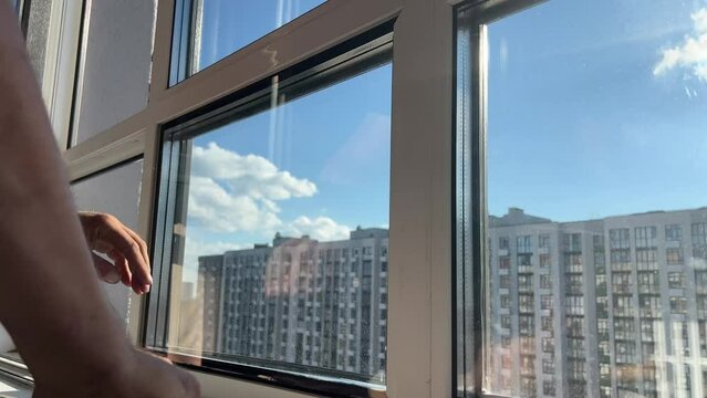 Window insulation process. A male craftsman installs double-glazed windows. Warming windows