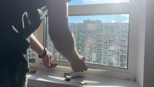 Window insulation process. A male craftsman installs double-glazed windows. Warming windows