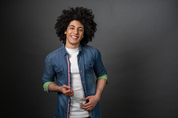 Curly-haired young man feeling good and smiling