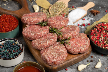 Raw beef patties. Fresh raw beef meatballs on dark background. Butcher products. Close up