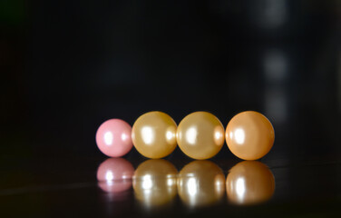 Real pearls Selected, beautiful color, laying on the ground, with reflection.
