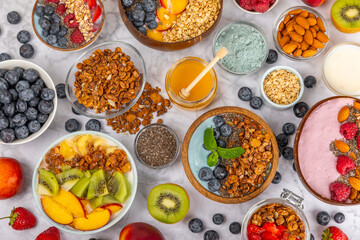 Bowl of granola with yogurt and fresh berries on a texture table. Yogurt berries, acai bowl, spirulina bowl. Healthy food, balanced breakfast. Strawberries, blueberries, kiwi, peach, almonds and chia.