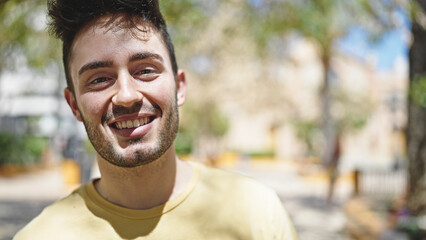 Young hispanic man smiling confident standing at park