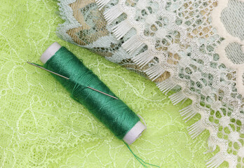 the macro shot of the thread bobbin laying on the textile lace 