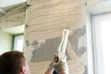 Machine plastering. Applying gypsum plaster by mechanized method in apartment.