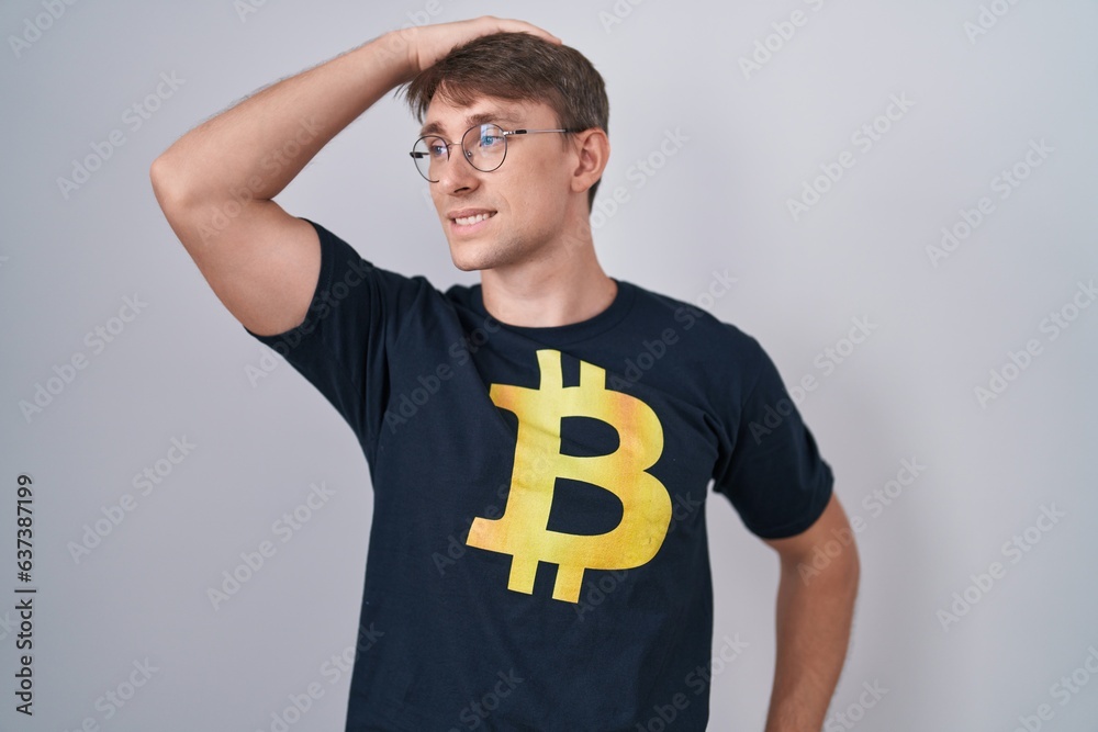 Poster caucasian blond man wearing bitcoin t shirt smiling confident touching hair with hand up gesture, po