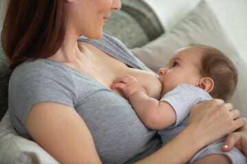 Obraz na płótnie Canvas young woman breastfeeding her baby