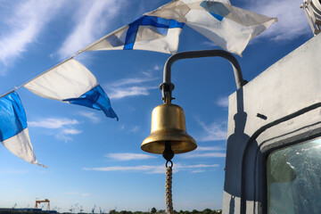bell on a boat with ceremony flags