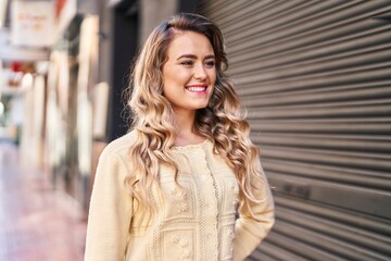 Fototapeta premium Young woman smiling confident looking to the side at street
