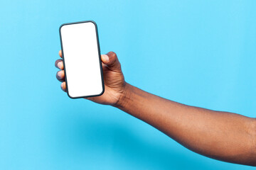 african american man's hand holding smartphone with blank screen on blue isolated background