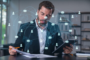 Considered businessman in formal wear signing contract holding tablet device at office room with papers. Concept of successful business deal, agreement, partnership, documents. Social network icons.