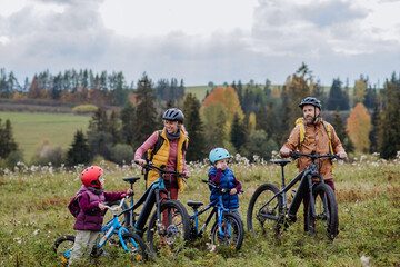 Young family with little children at bicycles, in the middle of autumn nature.Concept of a healthy...