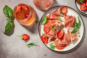 Slices of prosciutto di parma or jamon serrano iberico with strawberries, Antipasto Dinner or aperitivo party, place for text, top view